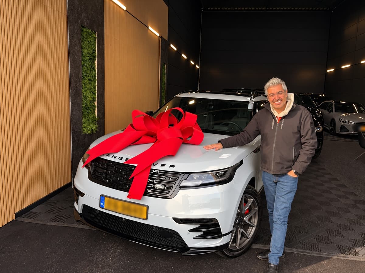 Witte Range Rover Velar met rode strik bij aflevering